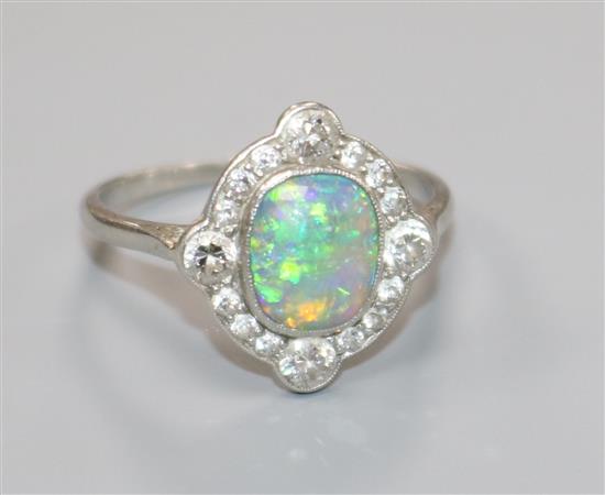 A 1920s white metal, black opal and diamond cluster ring, size P.
